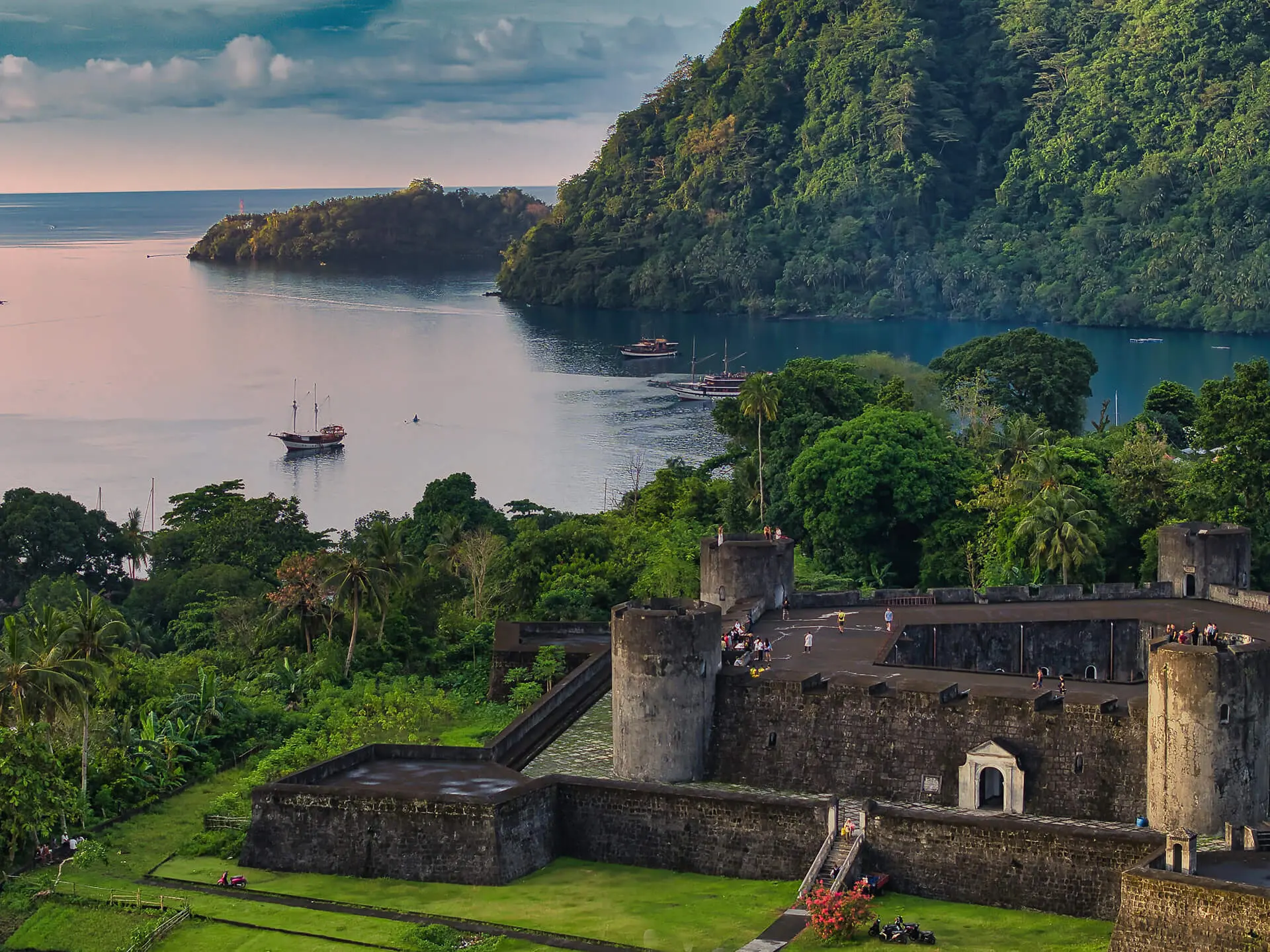 Explore the beauty of Fort Belgica, a historic landmark on Banda Neira Island, Indonesia. This image showcases the fort's imposing structure against a backdrop of stunning natural scenery, including a calm bay and lush green islands. Book your trip to Banda Neira today