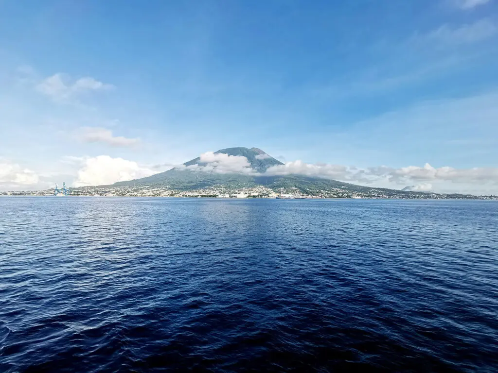 A majestic view of Mount Gamalama, an active volcano on Ternate Island in the Spice Islands of Indonesia. The volcano rises dramatically from the sea, creating a stunning natural landmark.